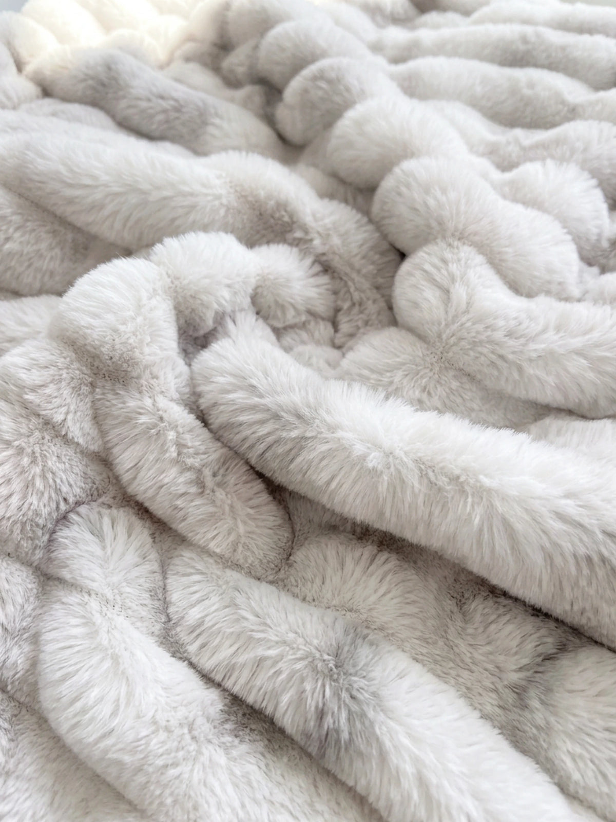 Nahaufnahme des Kunstfells in Weiß mit grauer Marmorierung